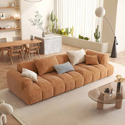 Brown sofa in a modern living room with a dining area in the background